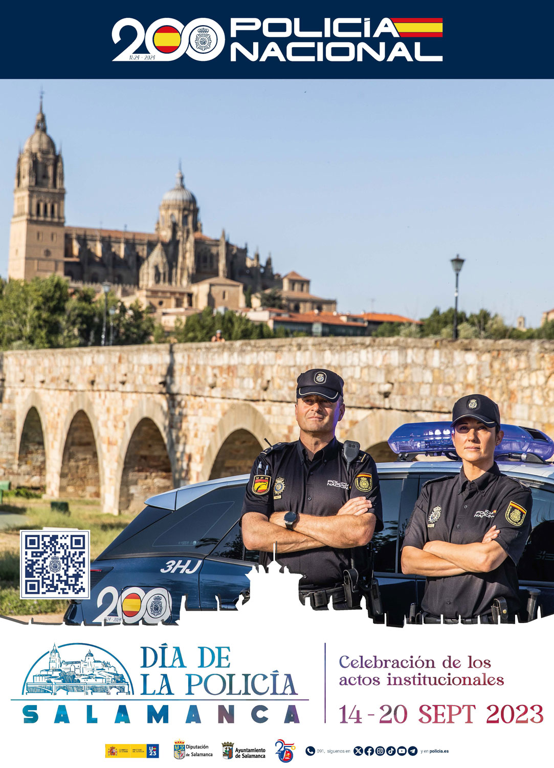 Cartell amb dos policies d'uniforme, home i dona, davant del Puente Romano de Salamanca.