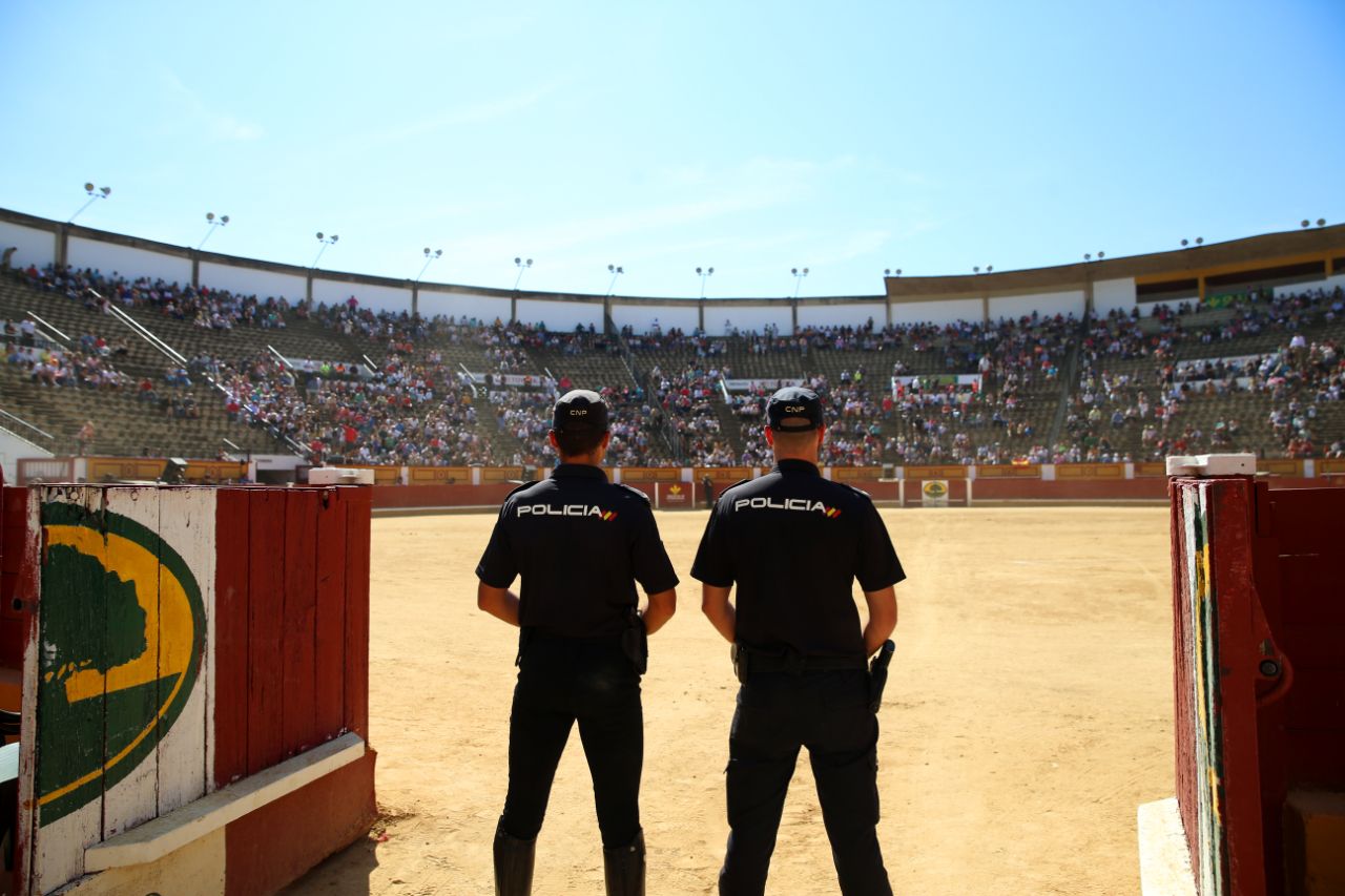 Plano general de la Plaza de Toros con dos policías de espaldas uniformados en primer plano.
