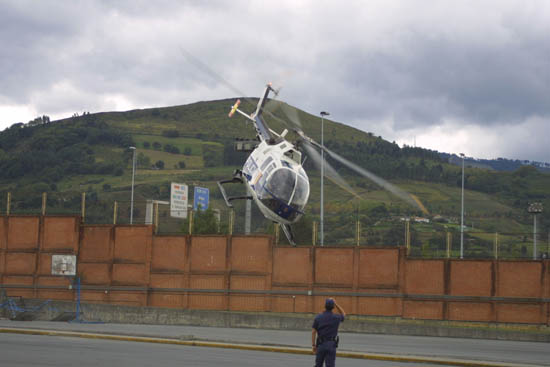 Helicóptero de Policía Nacional en vuelo de poca altura realizando una maniobra evasiva.