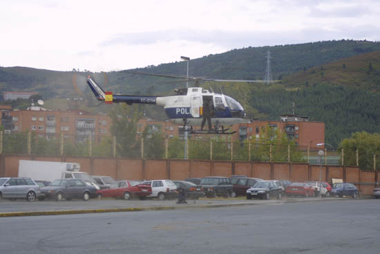 Helicóptero de Policía Nacional en vuelo de poca altura con despliegue desde el aparato de un miembro de Unidades Especiales.