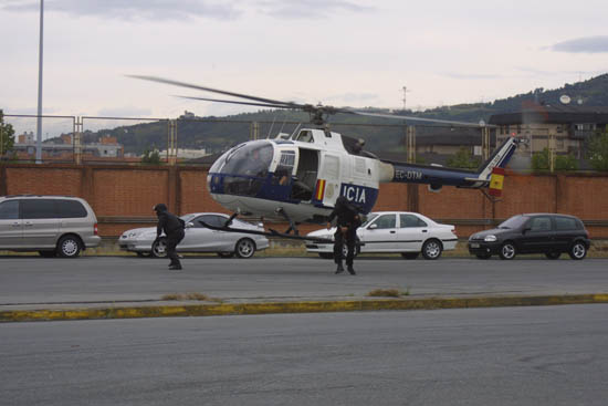 Helicóptero de Policía Nacional en vuelo de poca altura con despliegue desde el aparato de dos miembros de Unidades Especiales.