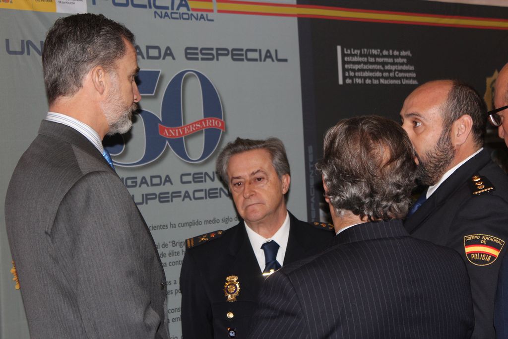 S. M. el Rey D. Felipe VI conversando con diversas autoridades policiales frente al cartel conmemorativo del 50 aniversario.