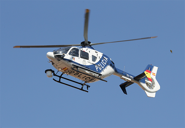 Imagen del helicóptero de la Policía Nacional en pleno vuelo. Se observa la parte baja y la parte lateral del aparato.