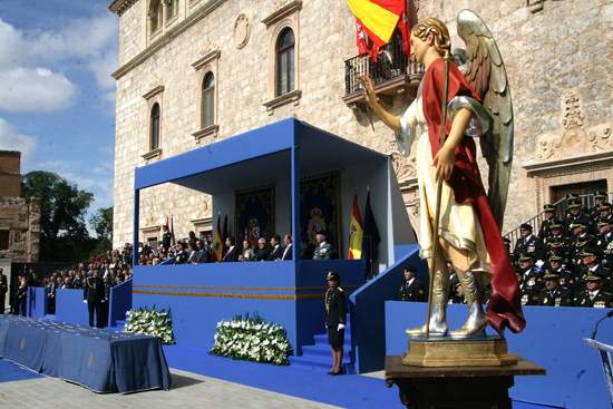 Una estatua del Santo Ángel Custodio y al fondo S.A.R. Don Felipe y Doña Leticia en el palco junto a otras autoridades.