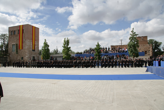 Plaza donde se celebra el acto y al fondo varias unidades policiales en formación.