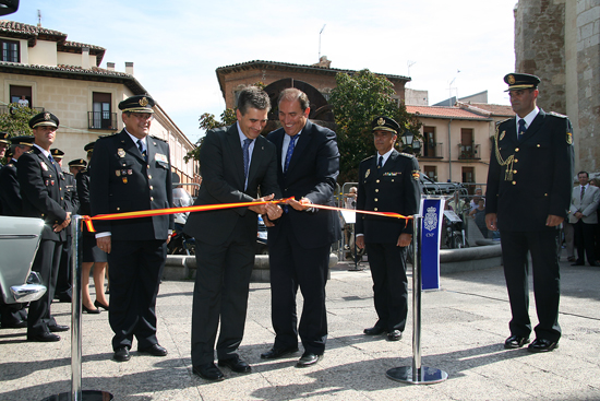 El Alcalde de Alcalá de Henares y el Director General de la Policía cortando la cinta de inauguración junto a varios Policías Nacionales.
