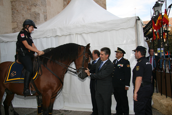 El Alcalde de Alcalá de Henares y el Director General de la Policía acariciando un caballo de Caballería junto a varios Policías Nacionales.