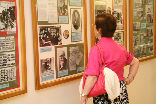 Una mujer observa un cuadro con varias fotografías e información sobre la Policía Nacional.