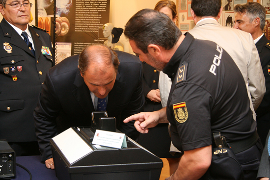 Un Policía Nacional explica el funcionamiento de un dispositivo al Alcalde de Alcalá de Henares.