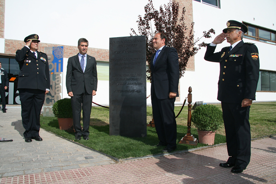 El Alcalde de Alcalá de Henares y el Director de la Policía, junto a dos Policías Nacionales en posición de saludo, junto a un monolito conmemorativo.