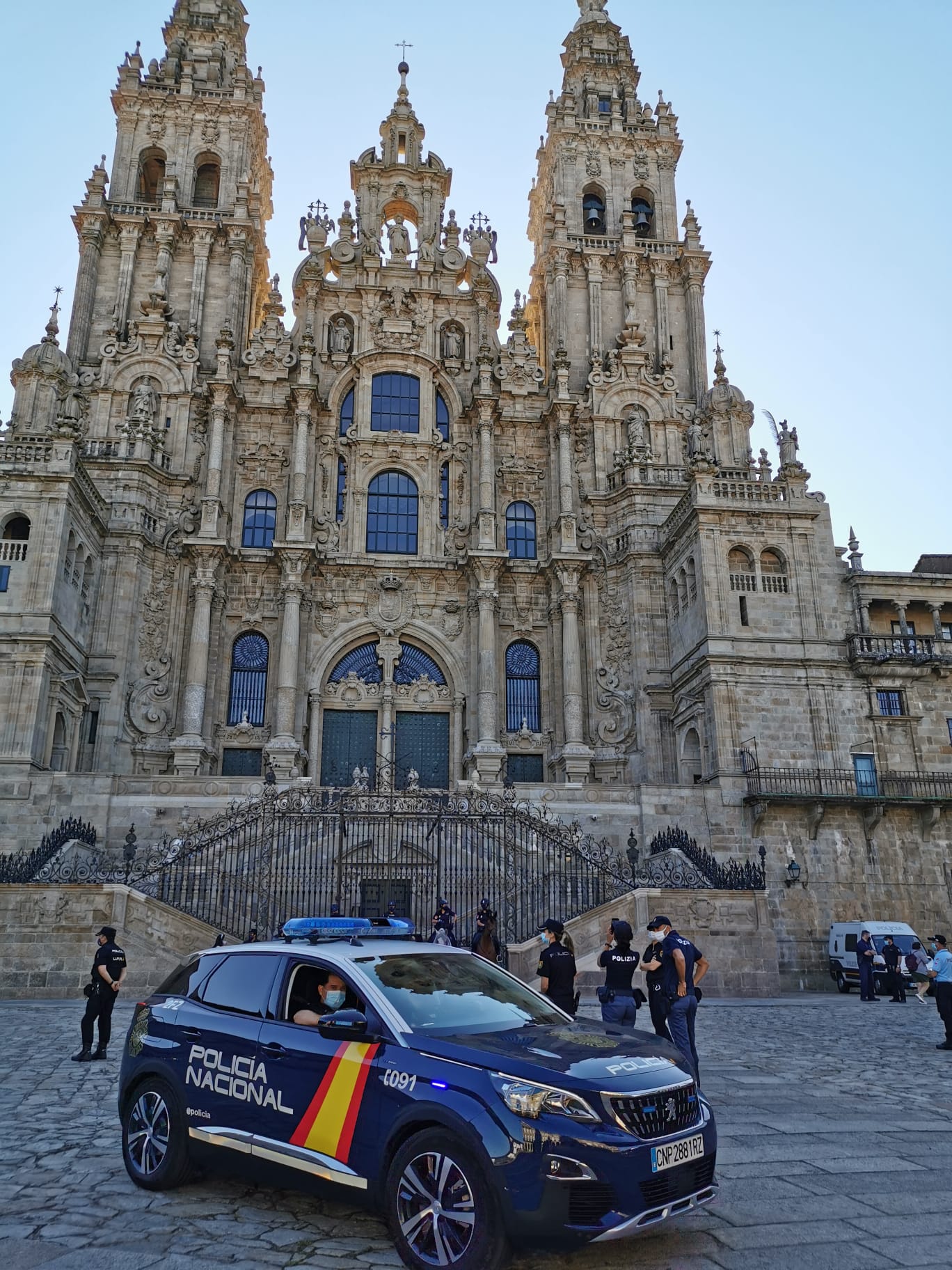 Un coche de Policía con varios policías delante de la Catedral de Santiago