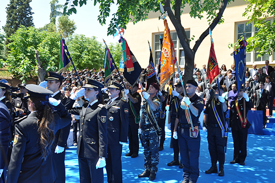 Policías Nacionales en formación portando banderines de distintas unidades policiales.