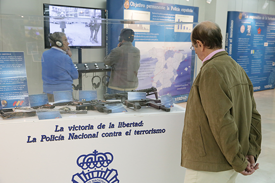 Visitante observa una vitrina de la exposición en la que se puede ver diversas armas de fuego y cargadores.