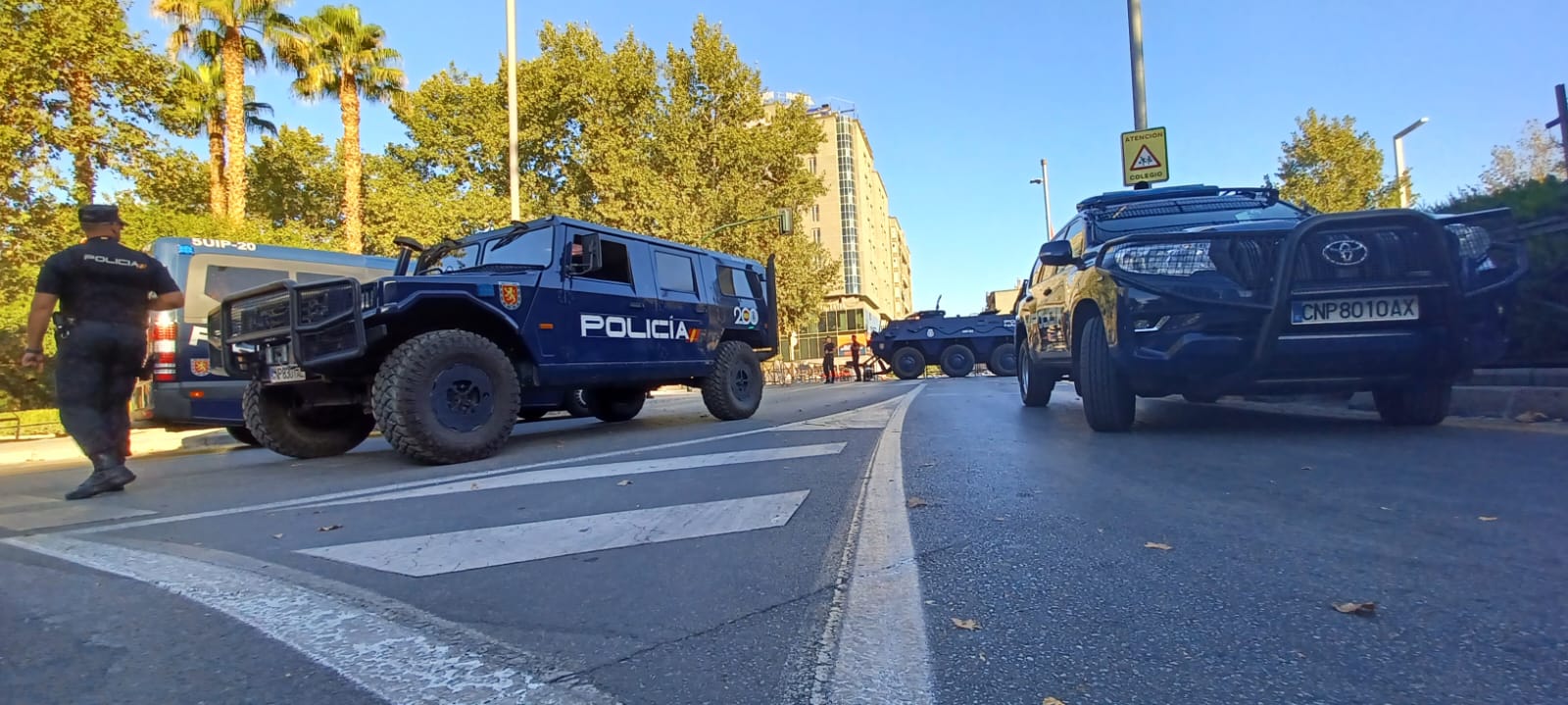 Agente de Policía Nacional junto a vehículos policiales