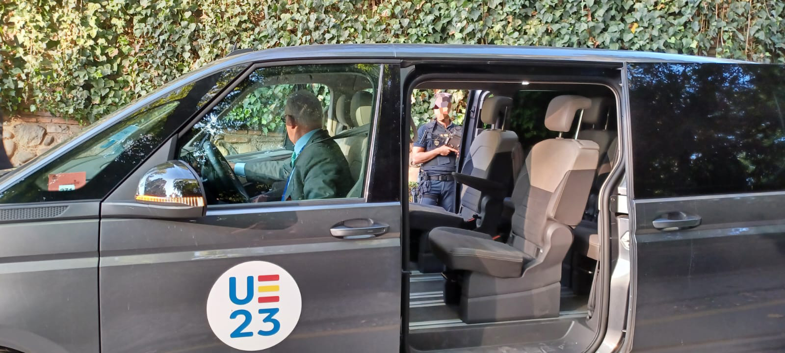 Vehículo oficial, con puerta abierta, con logo de la presidencia española de la unión europea.