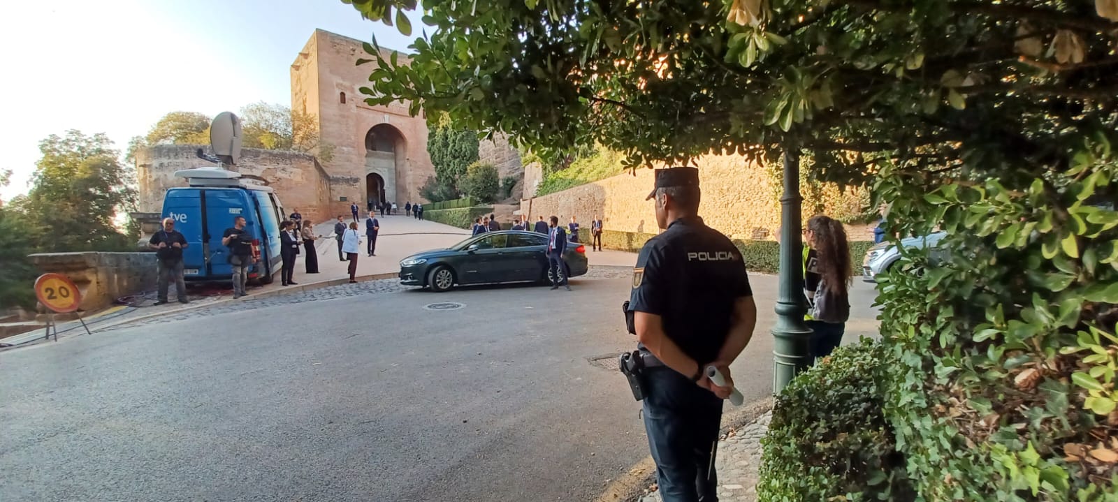 Agente de Policía, vehículo de prensa y otro oficial, a la entrada de la Alhambra.
