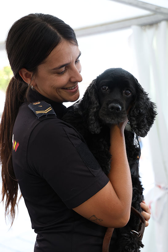 Fotografía en la que se ve como una policía posa con un perro.