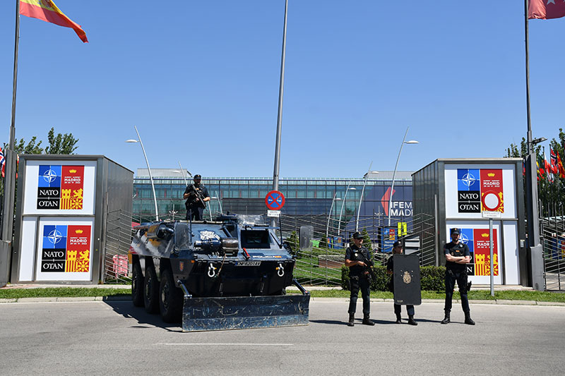 Agentes de la Policía Nacional junto a vehículo blindado BMR, en la entrada del recinto donde se desarrolla la cumbre.