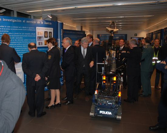 Autoridades, responsables de Policía Nacional e invitados,observando un robot de TEDAX y diversos paneles con información y fotografías.