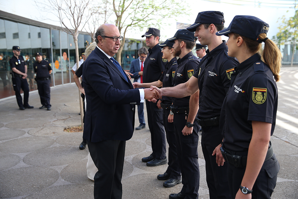 El Director General de la Policía saluda a varios policías en prácticas a la entrada de la exposición.