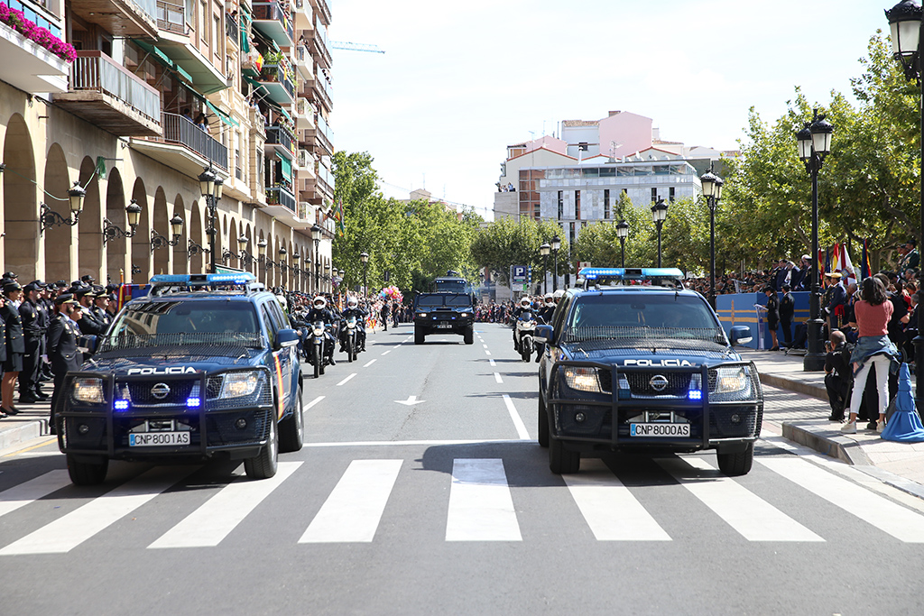 Desfile de vehículos de la Policía Nacional. Encabezan el mismo dos todoterreno, seguidos de motocicletas y más vehículos.