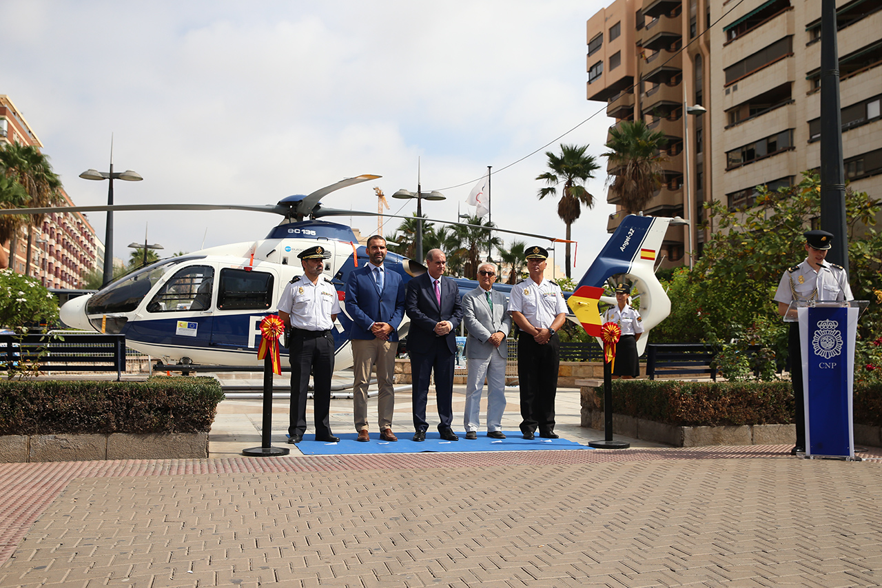 El Director General de la Policía junto a otras autoridades posando delante de un helicóptero de la Policía Nacional. 