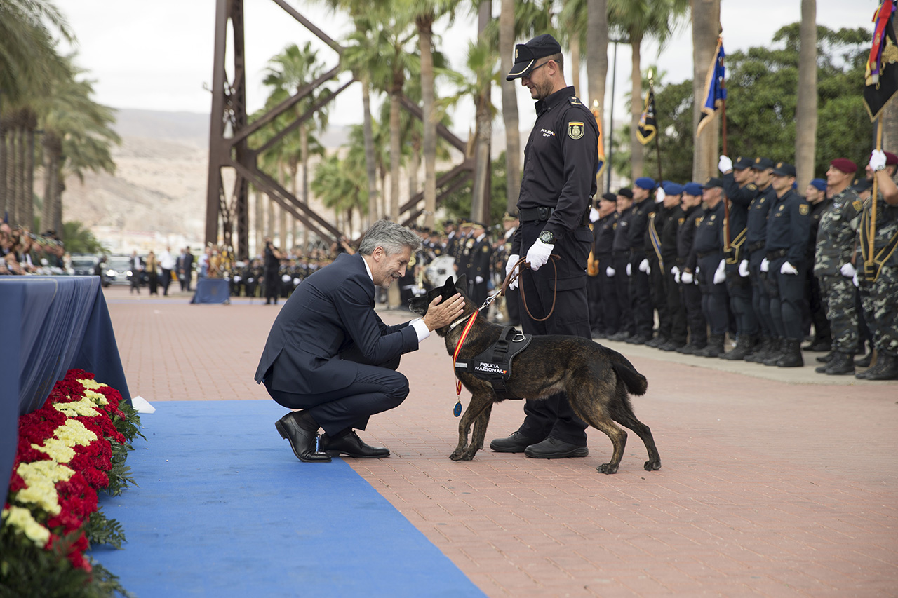 El Ministro del Interior acariciando un perro de la Policía Nacional en presencia de su Guía.