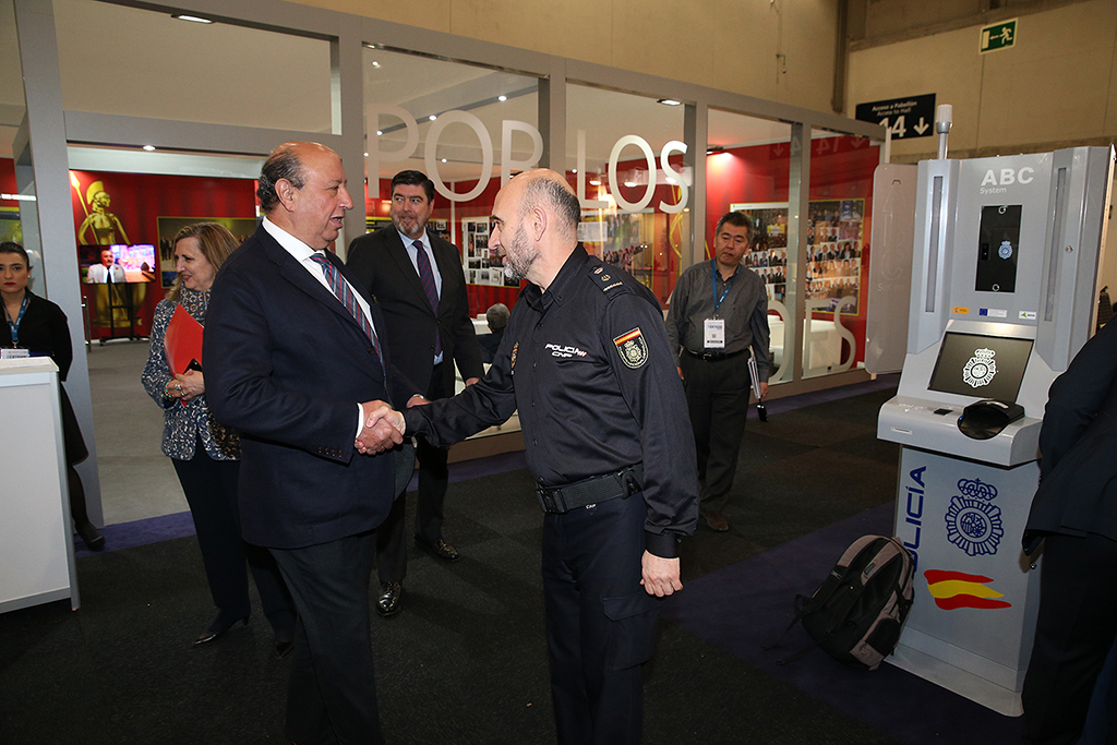 D. Germán López Iglesias, Director General de la Policía, saludando a un miembro de la Policía Nacional. Detrás,  otros participantes de la feria.