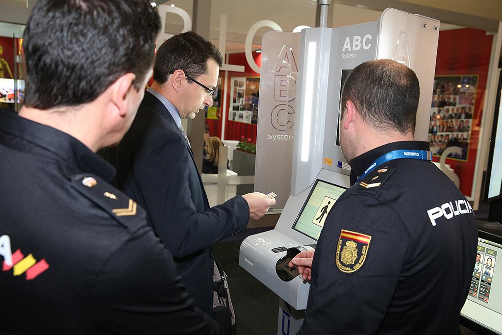 Dos policías explicando el funcionamiento del kiosco de ABC System para agilizar el cruce de frontera.